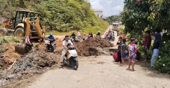 Alat berat saat sedang melakukan penggalian di jalan yang amblas