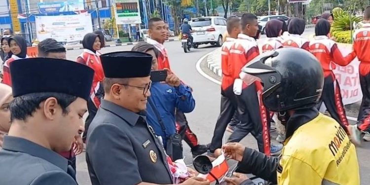 Walikota Jambi saat membagikan bendera merah putih
