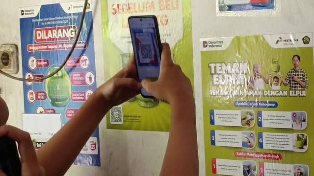 Warga membayar pembelian gas elpiji menggunakan metode QRIS.(MI/Haryanto Mega)
